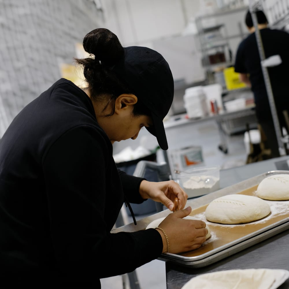 A woman makes dough at YVR Prep